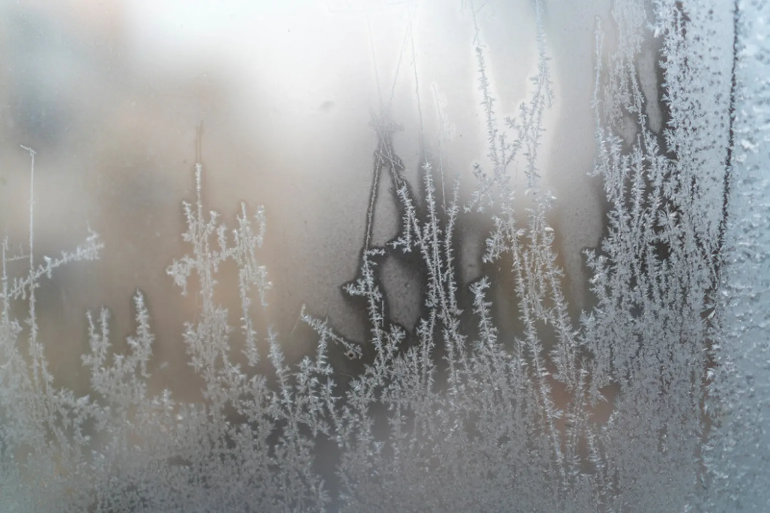 Iskrystaller og frost på en vinduesrude om vinteren